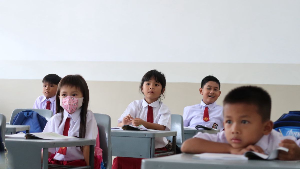 Siswa dan guru sedang belajar di kelas, mencerminkan dampak dari anggaran pendidikan.