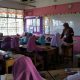 Seorang guru sedang mengajar siswa di kelas dengan penuh antusias.