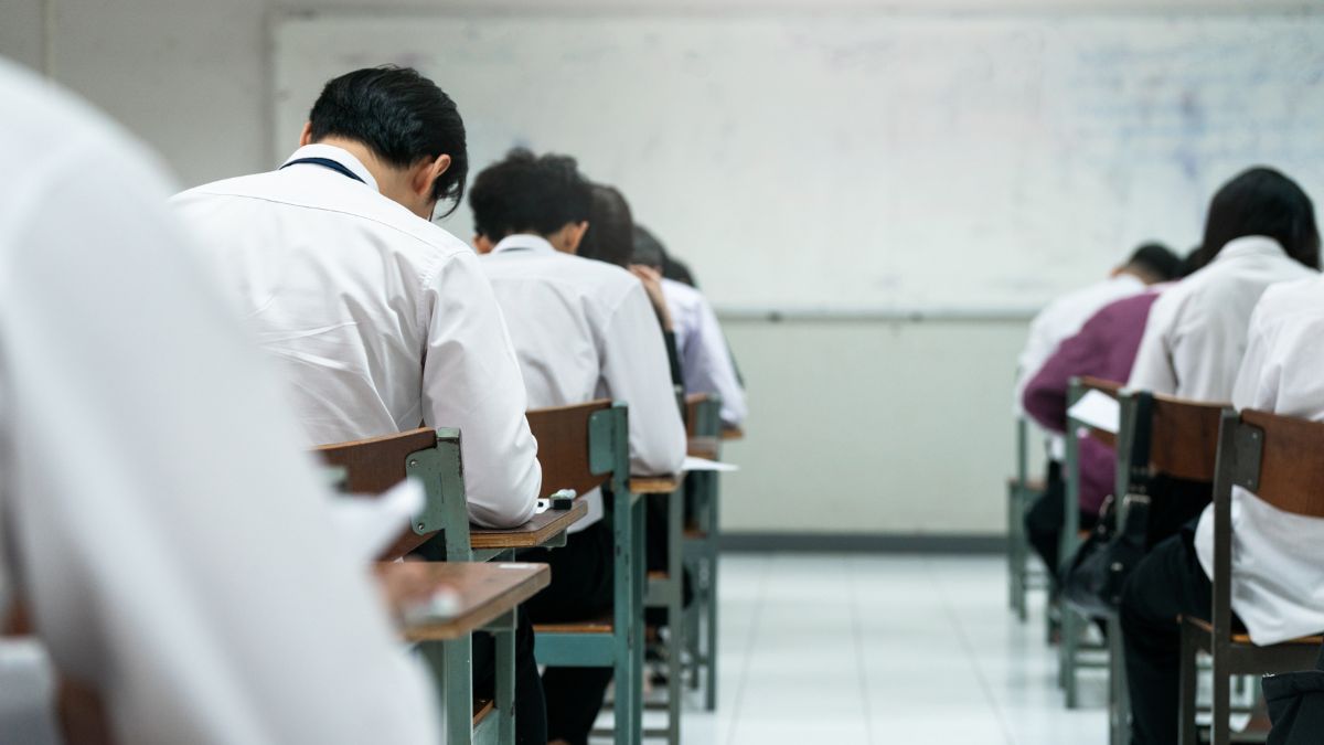 Seorang siswa SMA sedang membaca buku panduan pemilihan jurusan untuk Seleksi Nasional Berdasarkan Prestasi (SNBP) 2025.