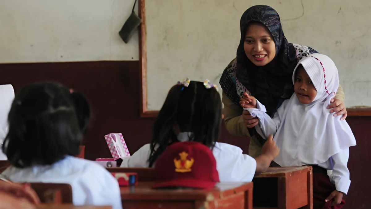 Guru mengajar siswa di kelas dengan suasana interaktif